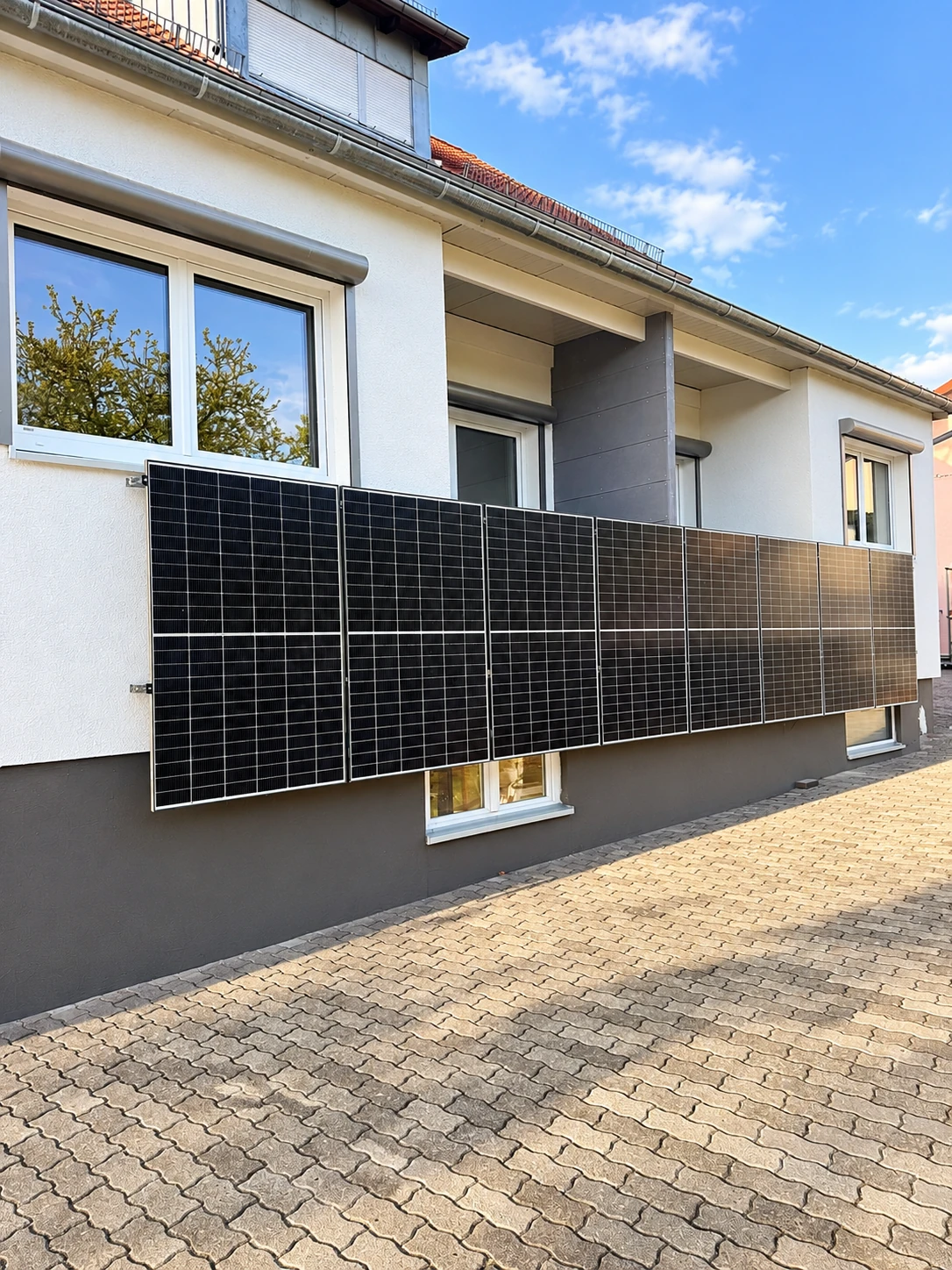 Wohngebäude Unslebener Straße 12 in Wollbach mit Solarmodulen an der Balkonbrüstung